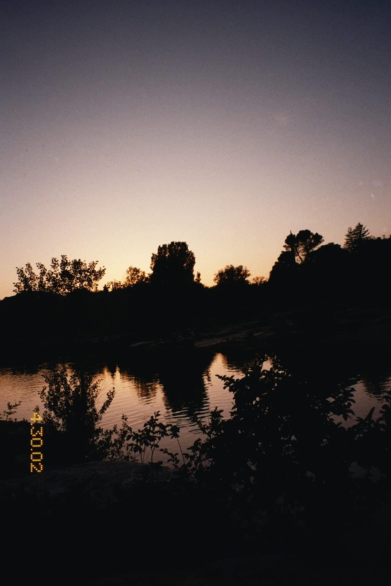 Sunset over a river treeline