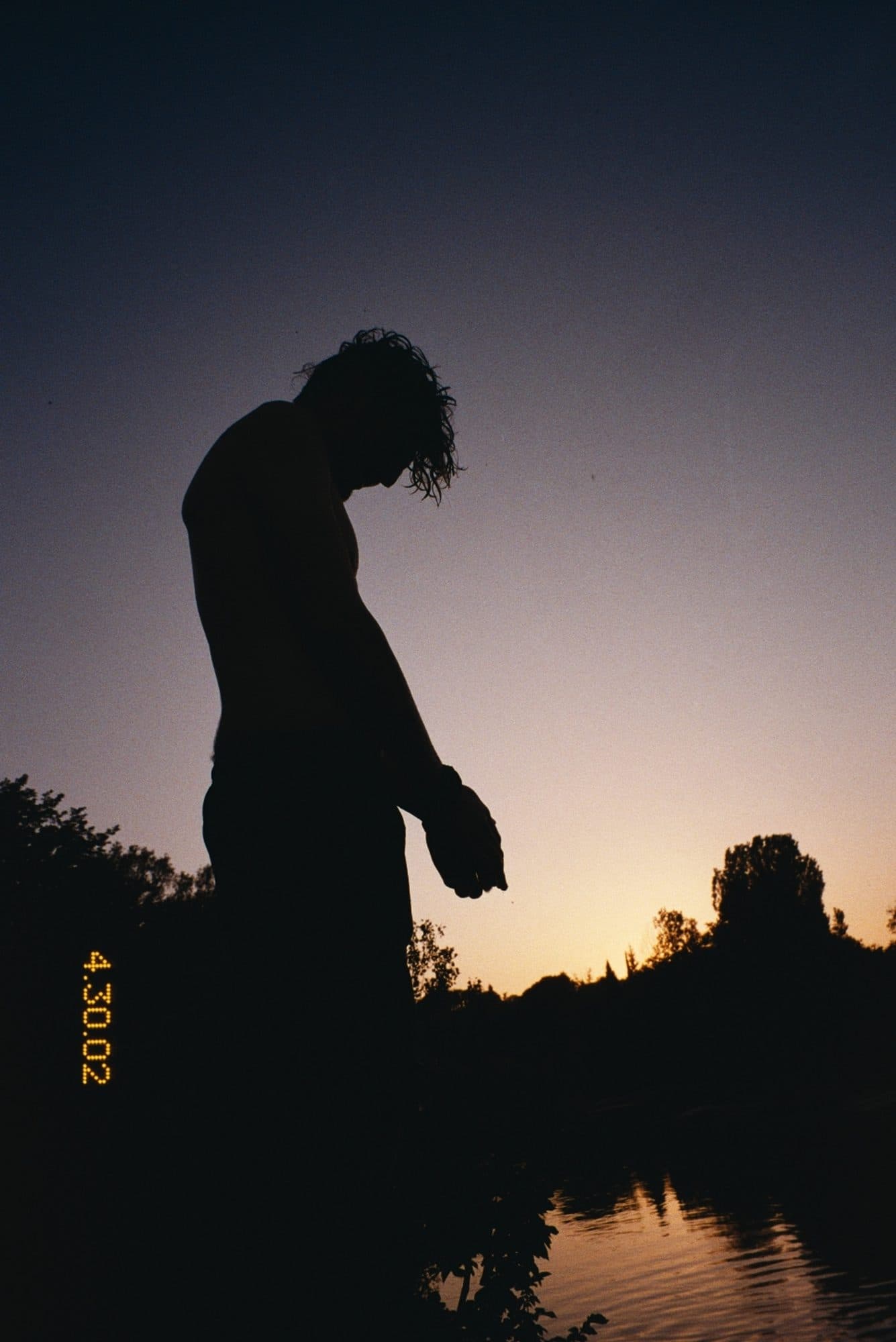 Silhouette against a dusk sky at the water's edge